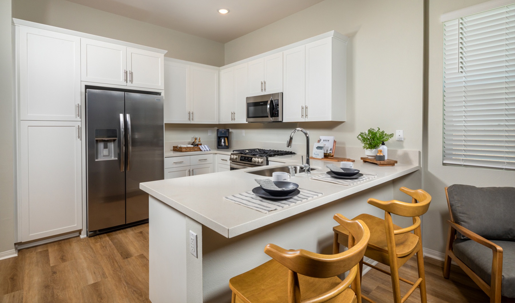 Live grand. Save big. a kitchen with a stainless steel fridge